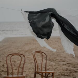 laundry hanging above chairs on beach shore